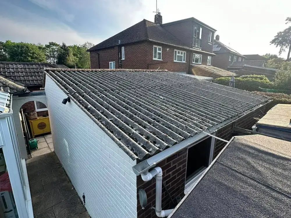 Old moss-covered pitched garage roof before replacement by A-List Roofing